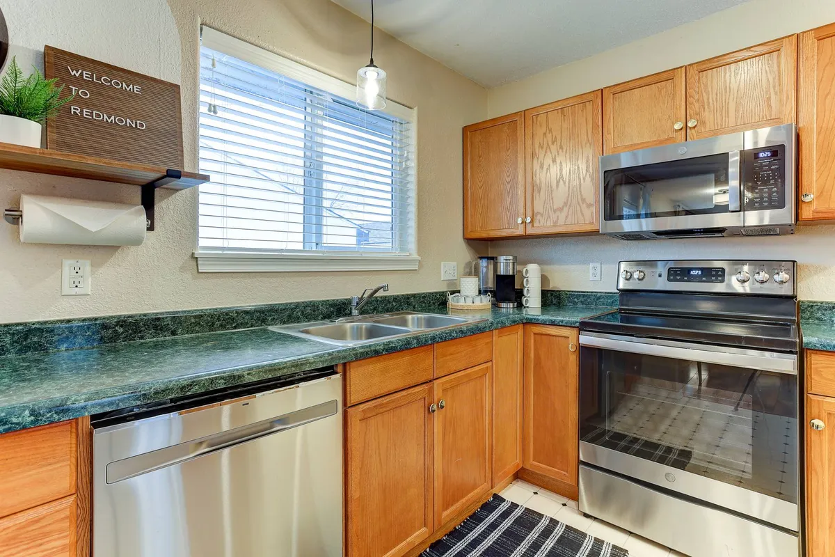 A welcoming kitchen with stainless steel appliances, a spacious countertop, a sink, and a 'welcome' sign, evoking feelings of hospitality and home-cooked meals.
